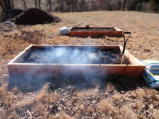 Preparing biochar in one of the other raised gardenbeds by partially burning and then smoldering piles of sticks collected off the ground under trees. With help from microbes and the earth worms that will be added later, this charcoal will rot and slowly release carbon and nutrients into the soil.